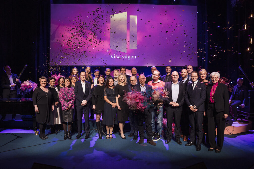 Stort antal människor är samlade på Visa vägen-scenen för gruppbild.