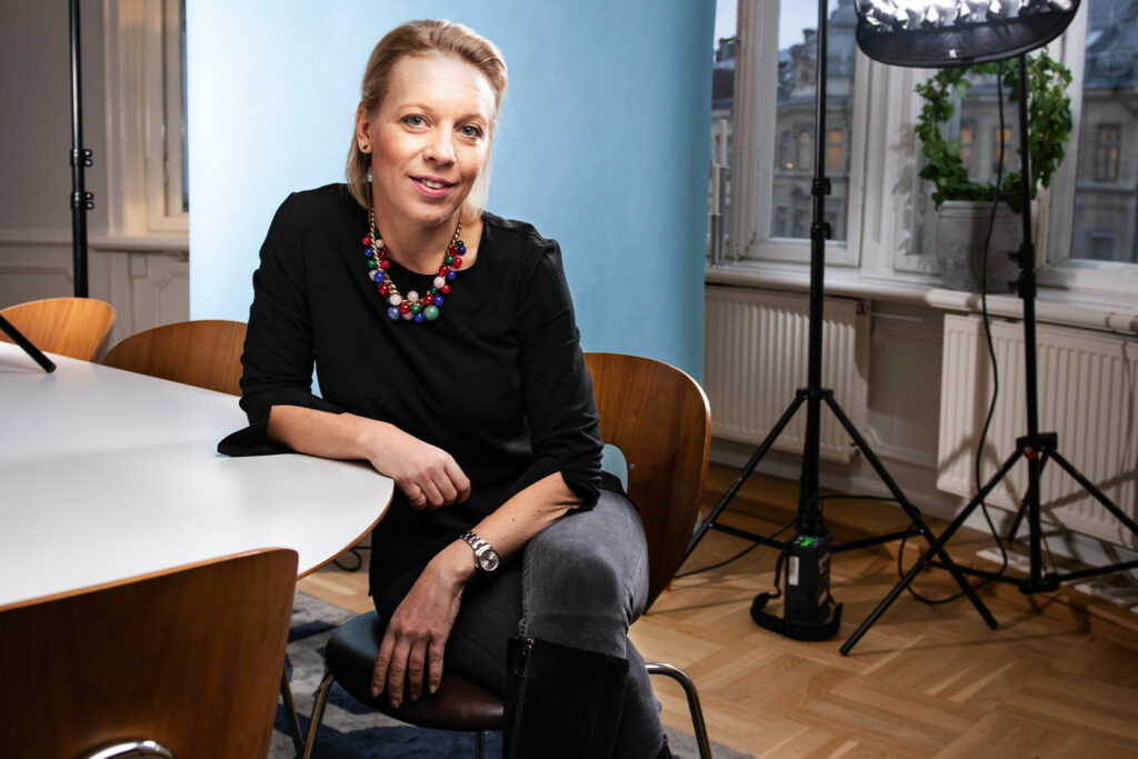 Porträtt av Maria Rankka som sitter lutad med sin högerarm på ett bord